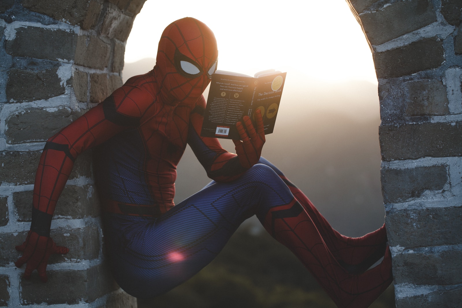 Spider-Man lutar sig mot betong och läser